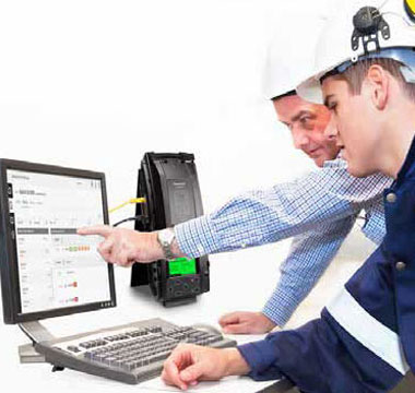 Two workers looking at computer, and IntelliDox is beside it
